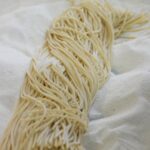 Frische italienische Pasta auf Backpapier, hausgemacht und traditionell zubereitet.