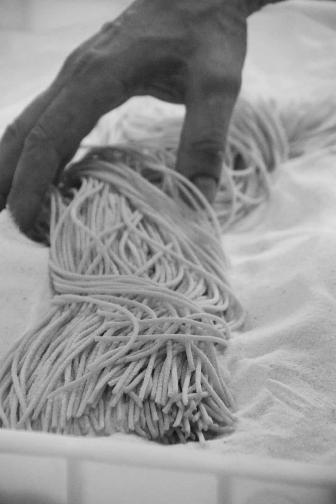 Spaghetti-Nudeln, die auf einem Tisch liegen, in schwarz-weiß.